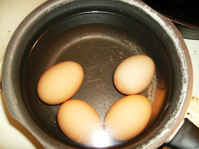 Four brown shelled eggs, hardboiled